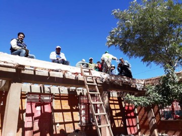 Familias trabajan en comunidad para cambiar techo de escuela